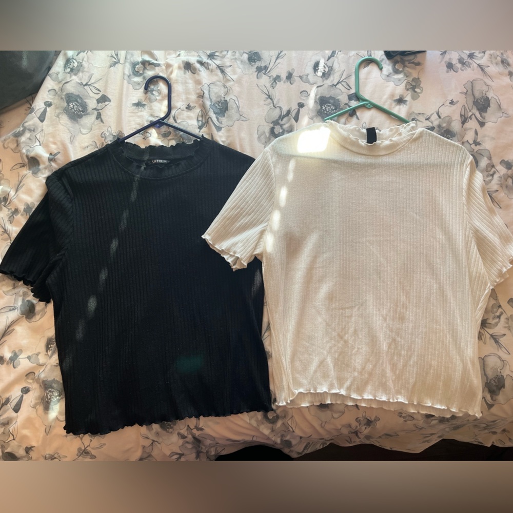 One black and one white basic blouses. Slightly see-through. Ruffled edges.